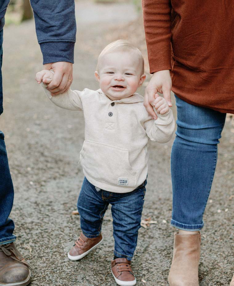 Parents holding toddler's hands